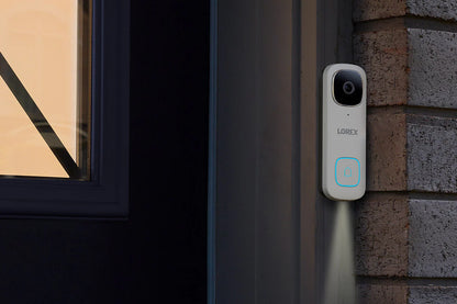 Lorex doorbell camera mounted on a brick wall next to a window.